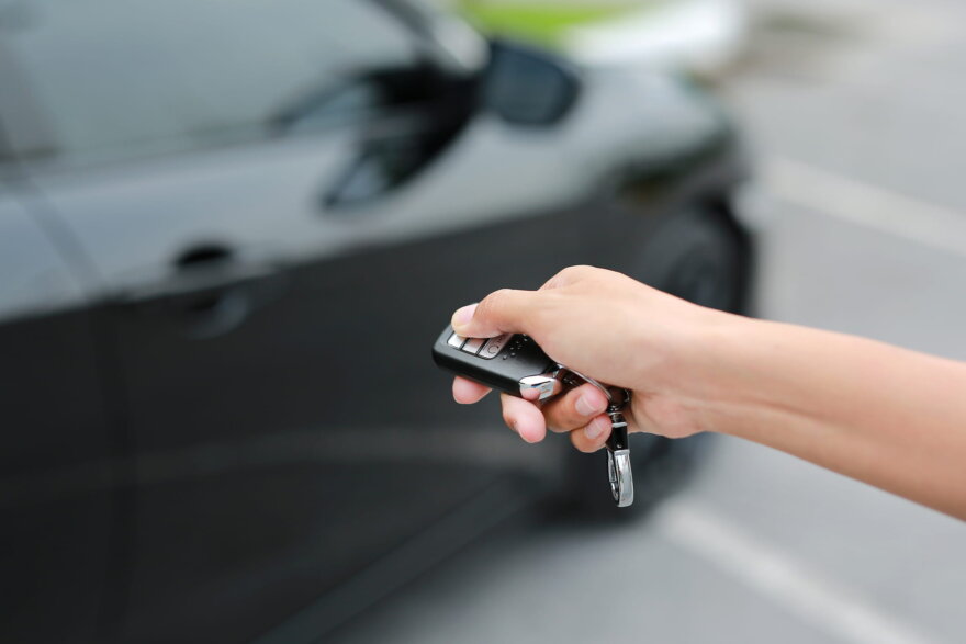 Hand Holding Button On The Remote Car For Close And Open The Door.